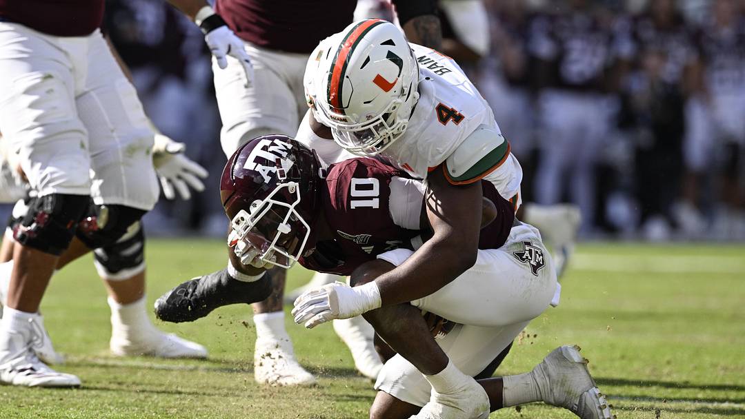 Dec 20, 2025; College Station, TX, USA; Texas A&M Aggies quarterback Marcel Reed (10) is sacked by Miami Hurricanes defensive lineman Rueben Bain Jr. (4) during the second half of the first round game of the CFP National Playoff at Kyle Field. Mandatory Credit: Jerome Miron-Imagn Images